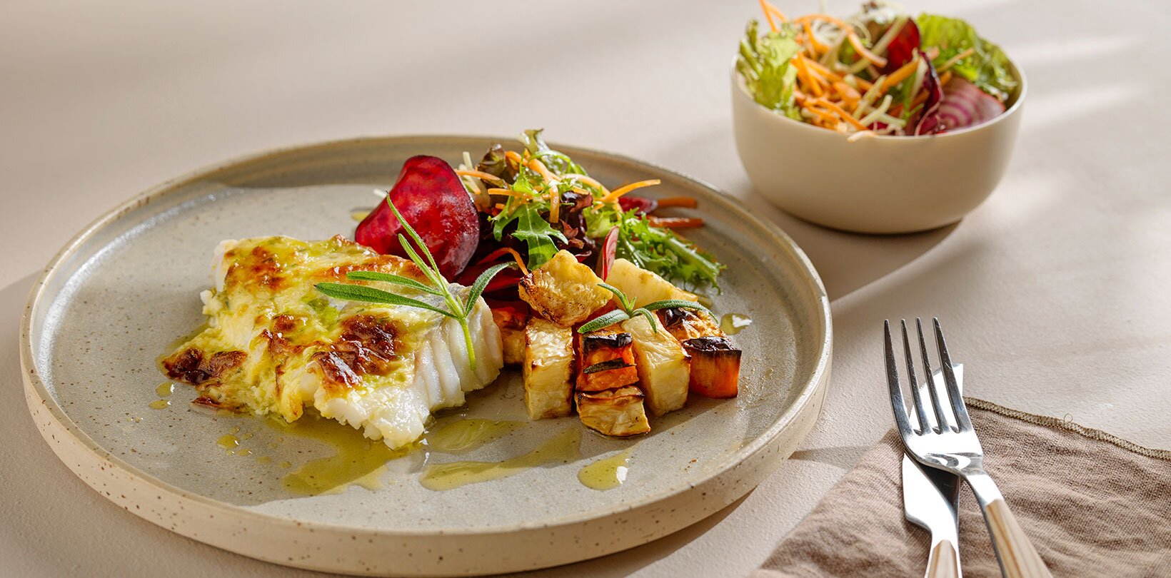Parmesangratinert skrei med rosmarinbakt selleri og søtpotet, og råkost