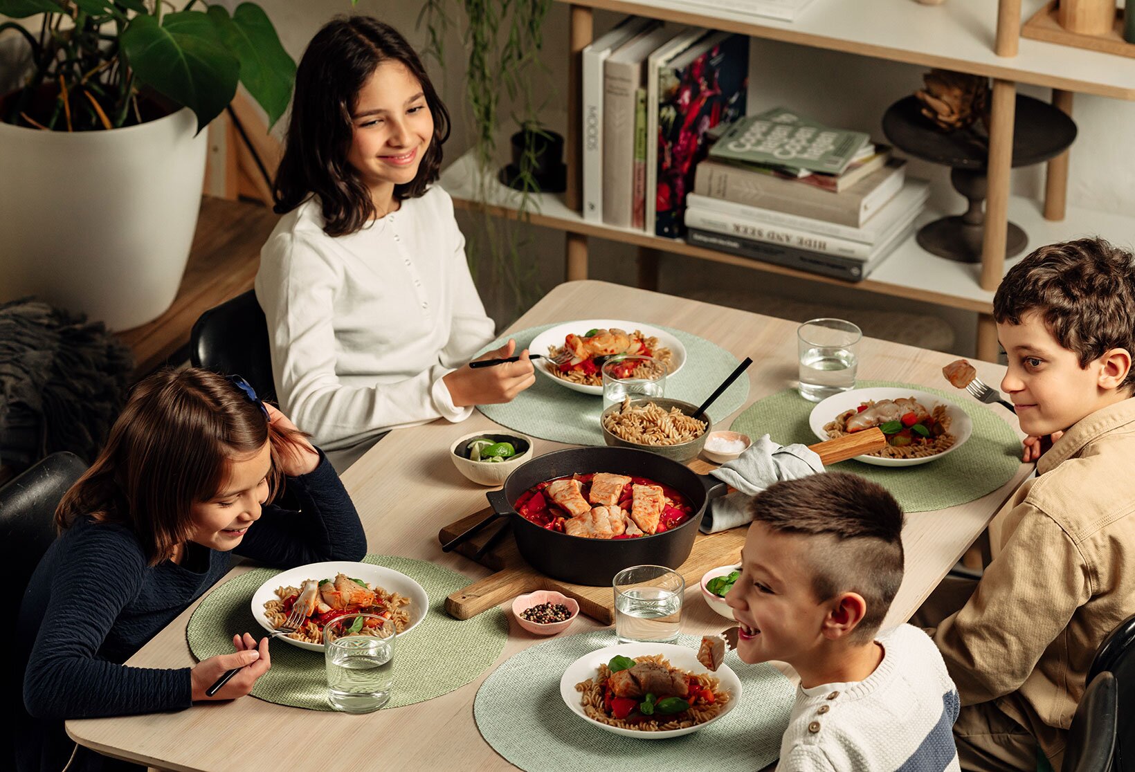 Barn rundt bordet som spiser sei