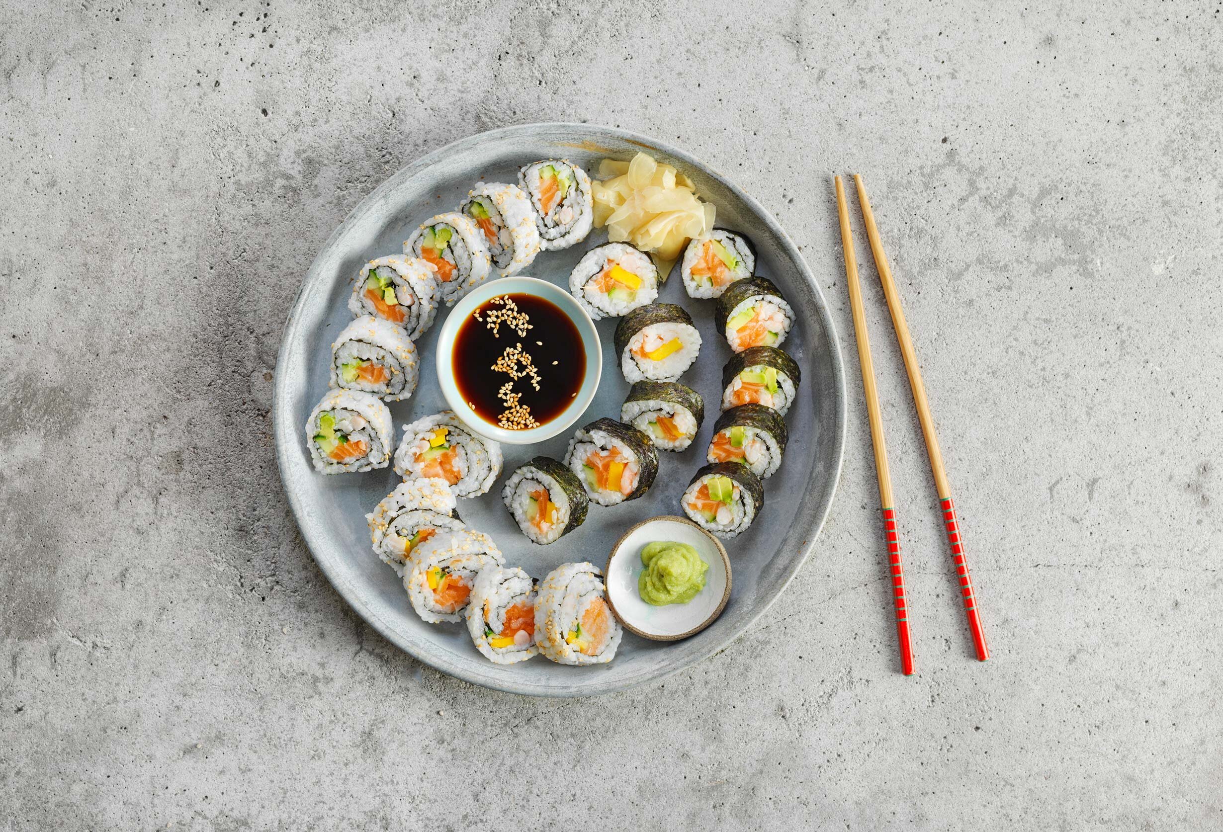 En tallerken fylt med masse forskjellig sushi typer