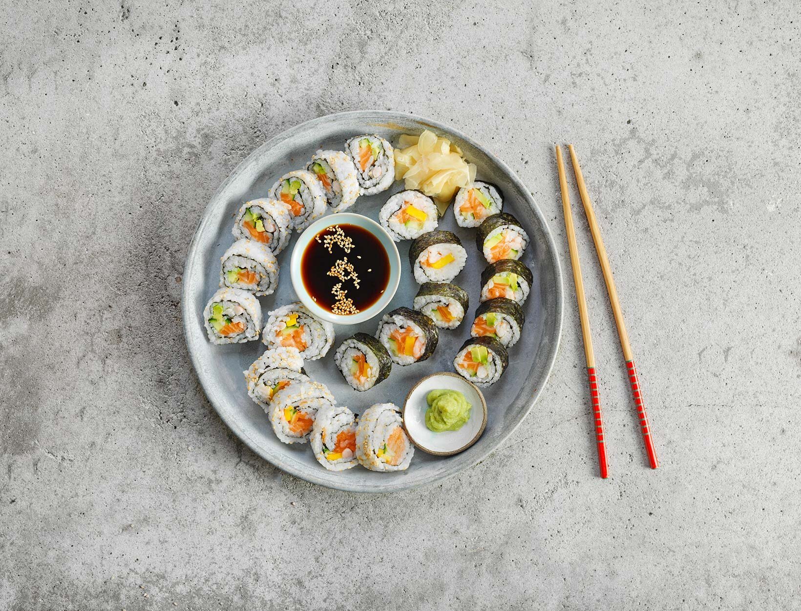 En tallerken fylt med masse forskjellig sushi typer