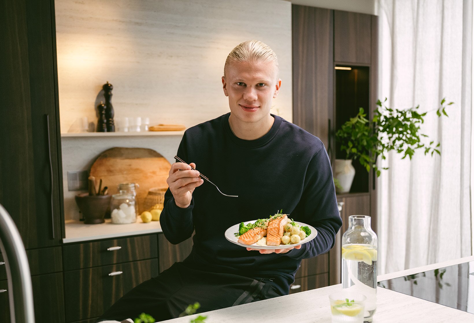 Erling Braut Haaland spiser laks på kjøkken
