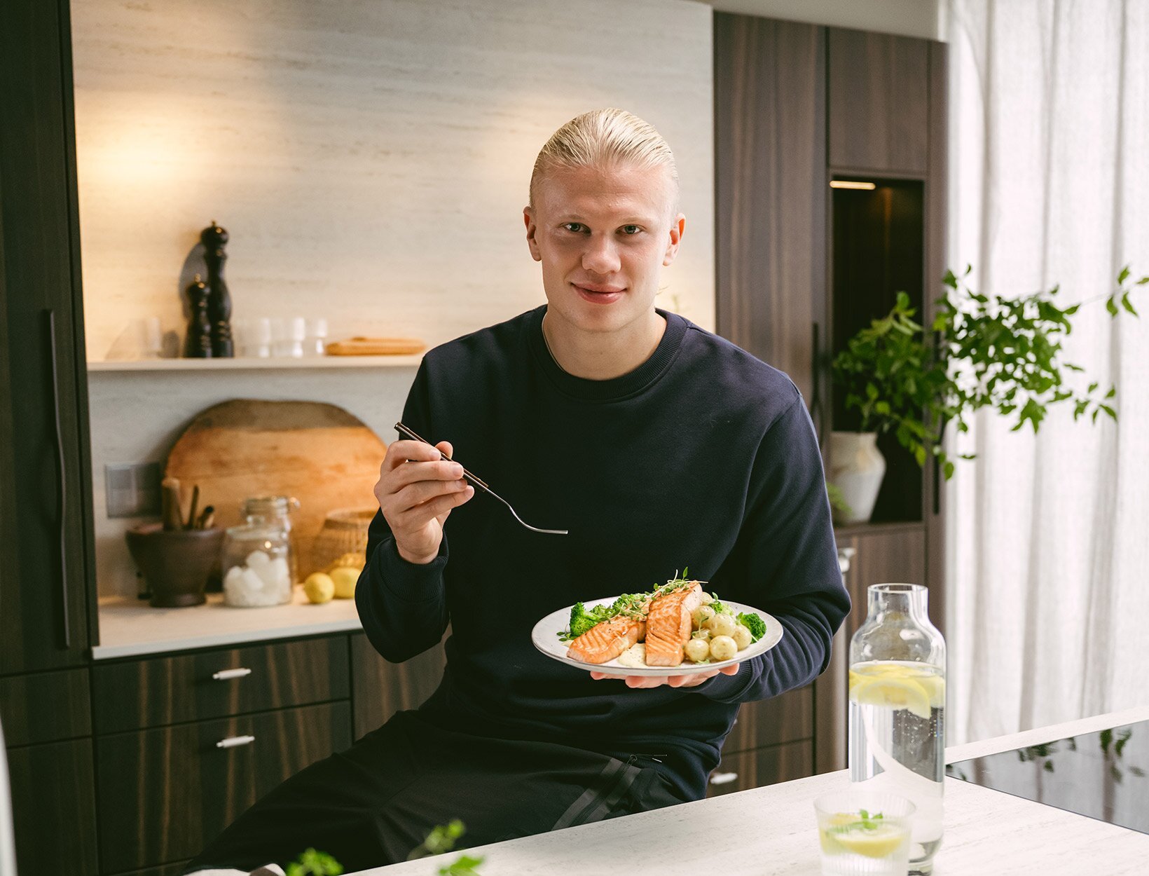 Erling Braut Haaland spiser laks på kjøkken