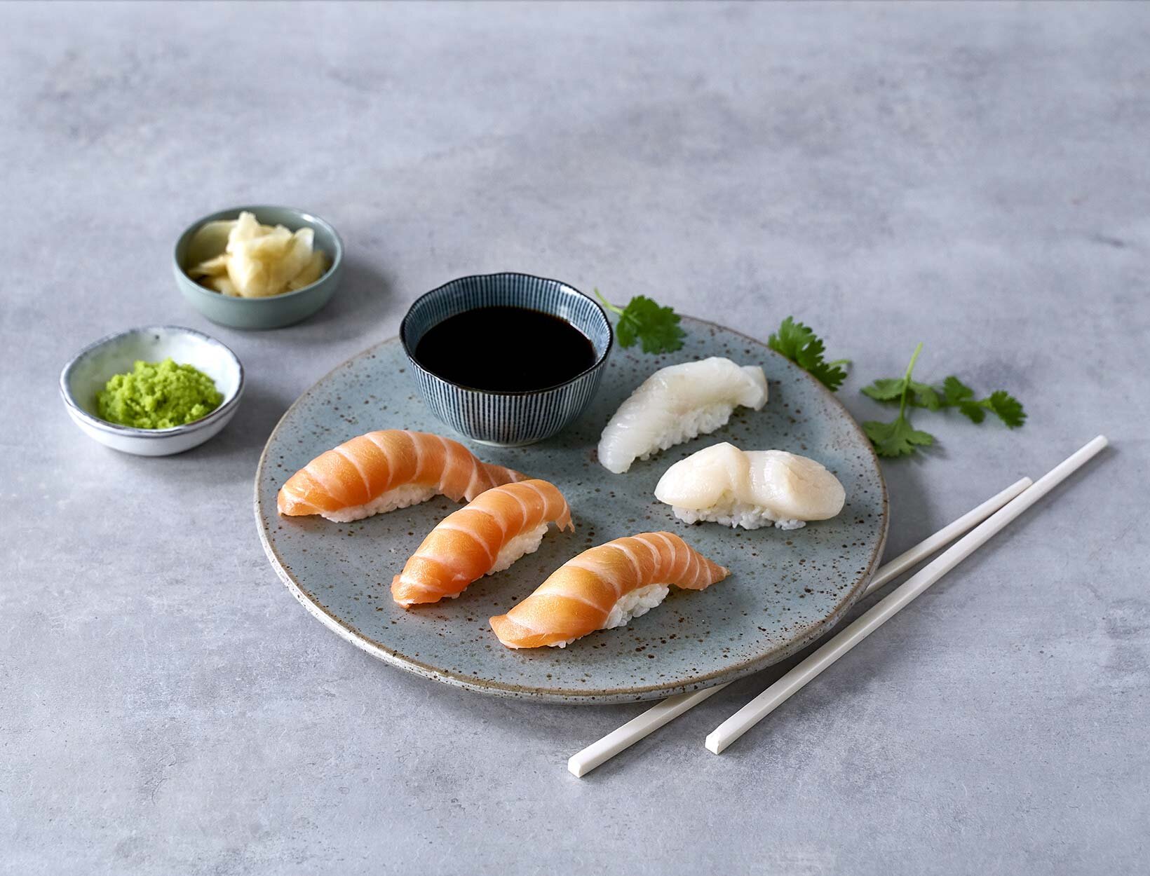 Nigiri sushi på en tallerken med tilbehør vedsiden